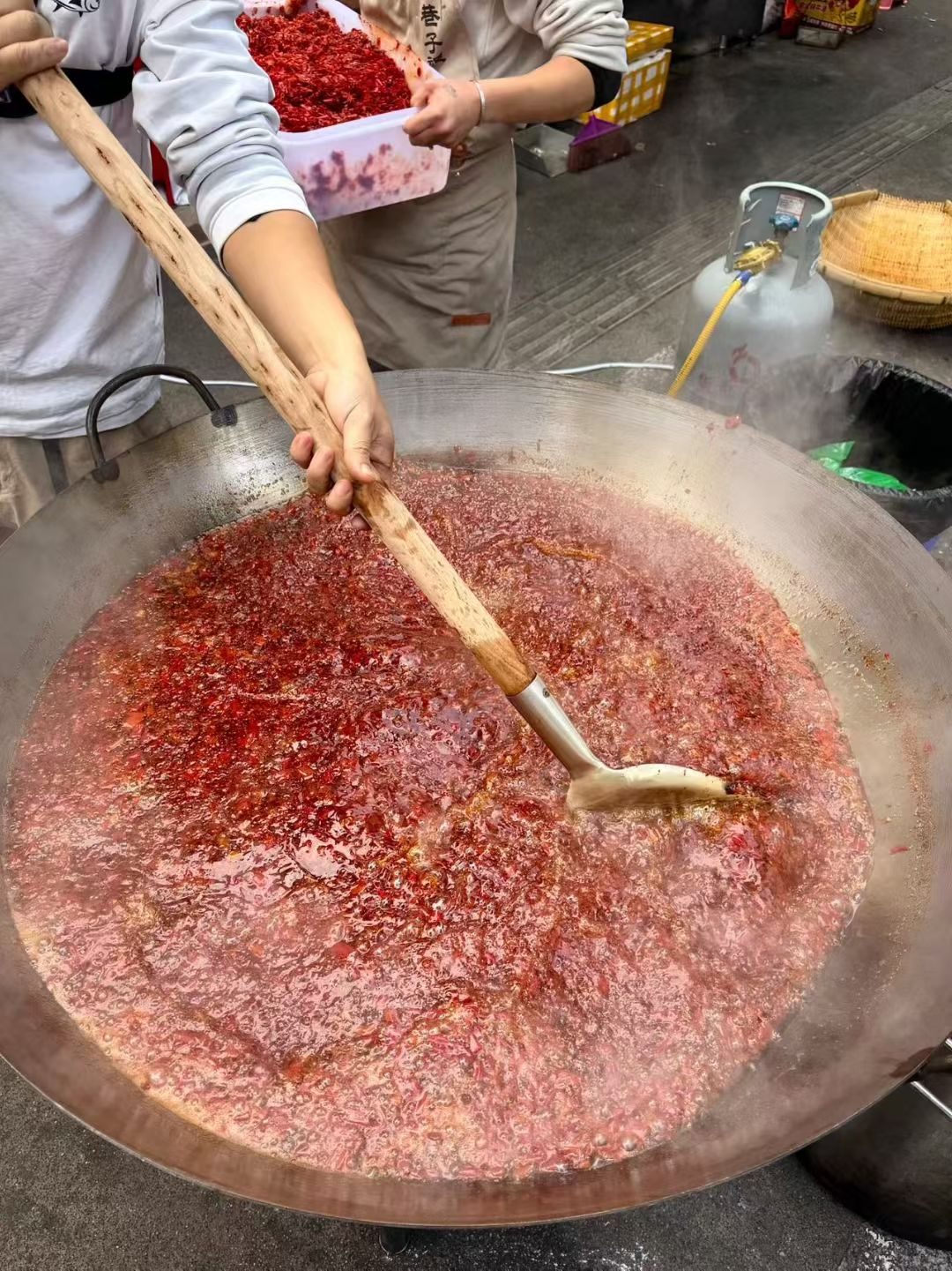 大铁锅里翻滚的糍粑辣椒，木长柄铲在慢慢搅动
